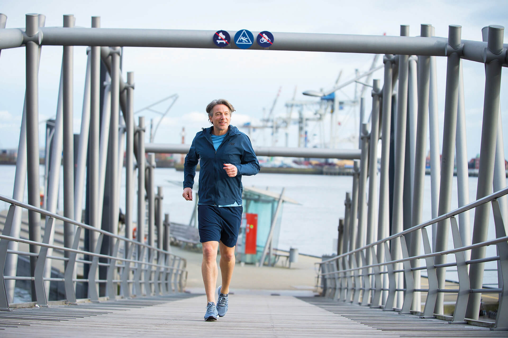 Mann joggt auf einer Hafenbrücke